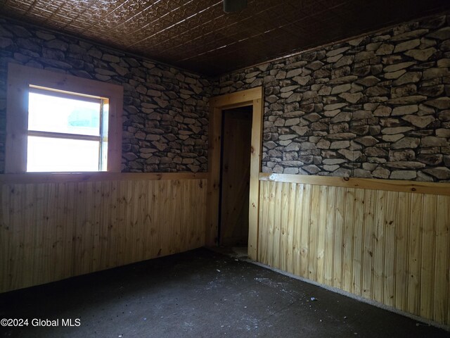 spare room with wood walls