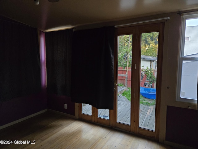 doorway featuring baseboards and wood-type flooring