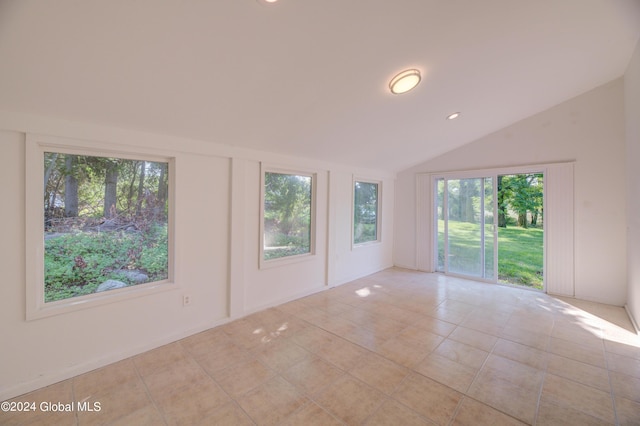 unfurnished room featuring lofted ceiling and light tile patterned floors