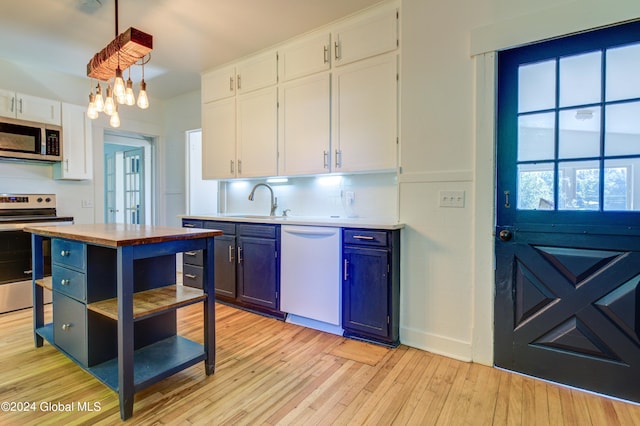 kitchen with light wood-type flooring, white cabinetry, tasteful backsplash, stainless steel appliances, and blue cabinets