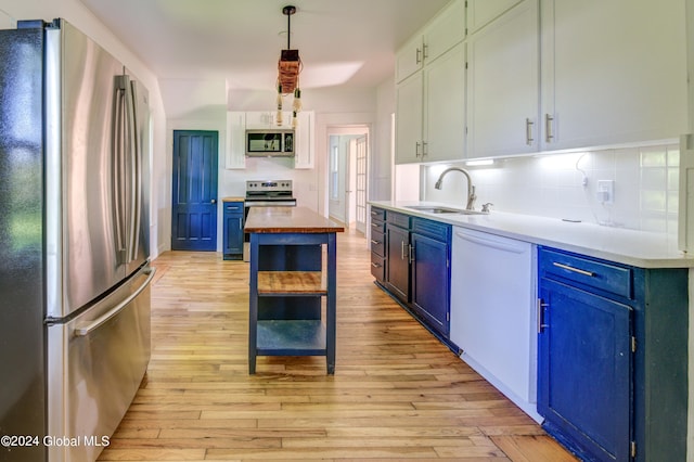 kitchen featuring blue cabinets, appliances with stainless steel finishes, sink, white cabinetry, and light wood-type flooring