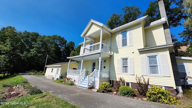 view of front facade featuring covered porch and a balcony