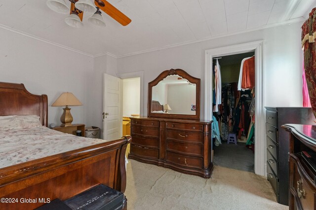 bedroom featuring light carpet, a closet, a walk in closet, ceiling fan, and connected bathroom