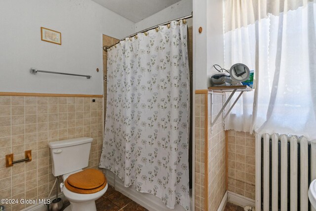 bathroom featuring tile walls, toilet, radiator heating unit, and tile patterned floors