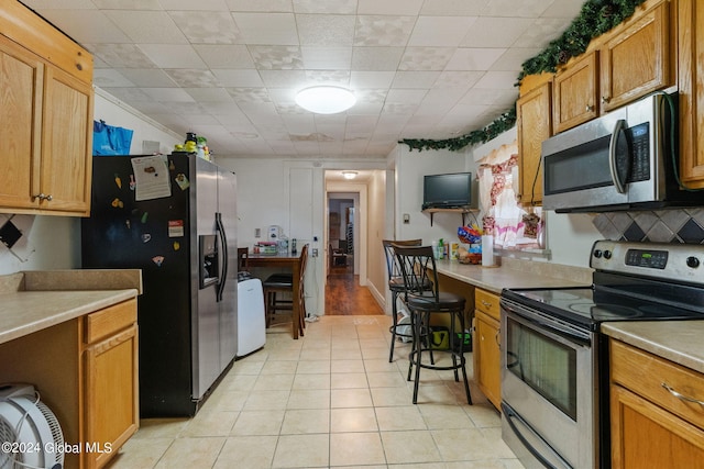 kitchen featuring appliances with stainless steel finishes and light tile patterned floors