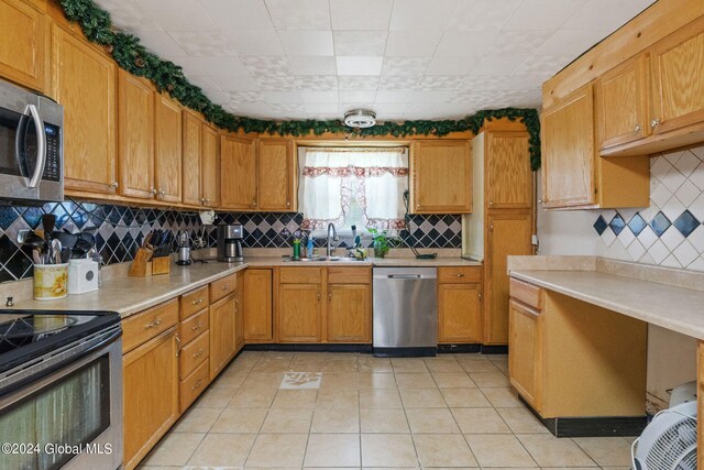 kitchen featuring appliances with stainless steel finishes, backsplash, and sink