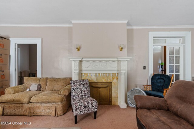 living room featuring crown molding, carpet flooring, and a fireplace