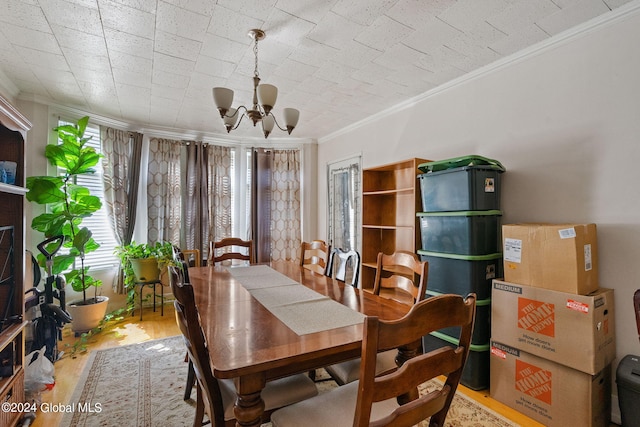 dining area with wood-type flooring, a notable chandelier, and ornamental molding