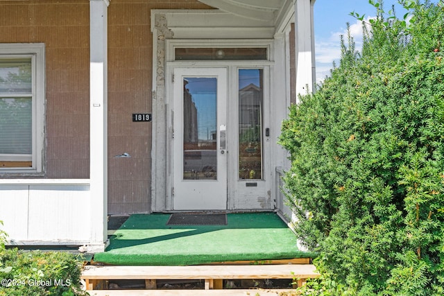 property entrance with a lawn