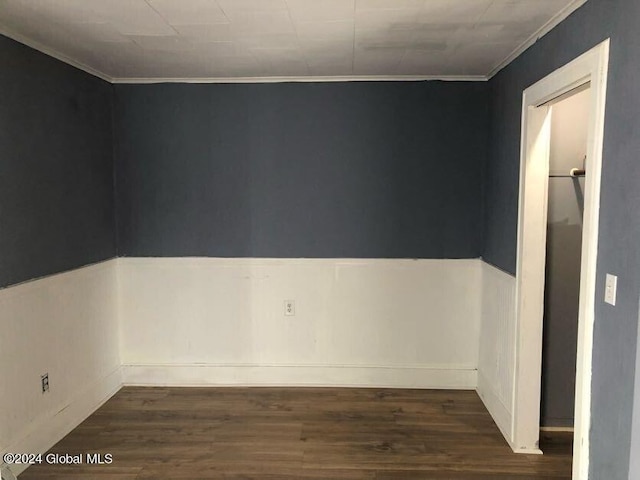 spare room with ornamental molding and wood finished floors