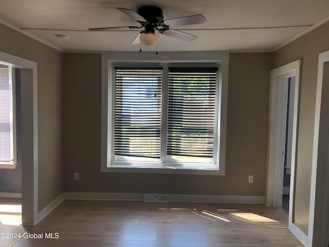 spare room with a ceiling fan, light wood-style flooring, visible vents, and baseboards