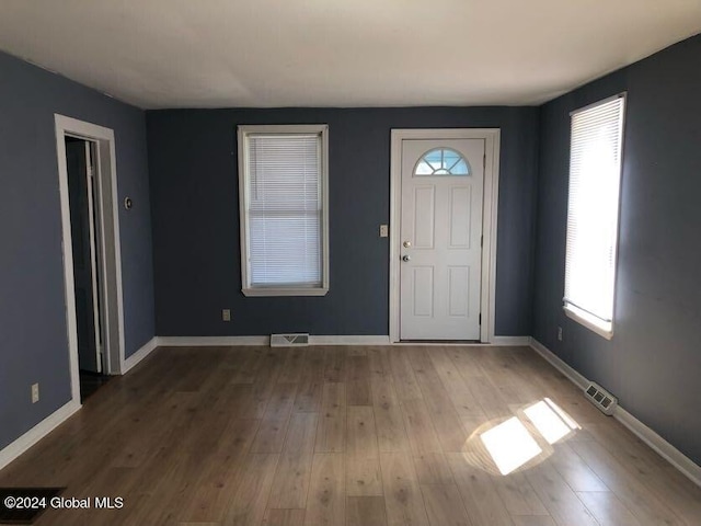 foyer with visible vents, baseboards, and wood finished floors