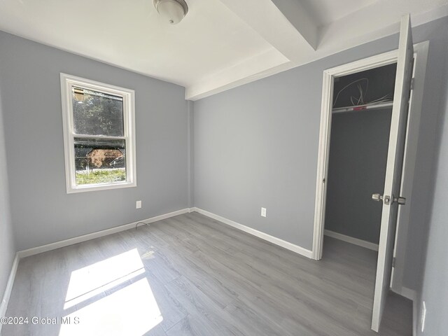 unfurnished bedroom featuring hardwood / wood-style flooring and a closet