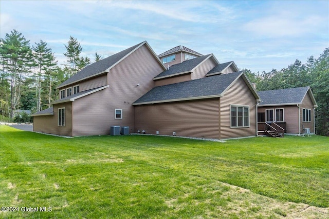 back of property featuring a lawn and central AC