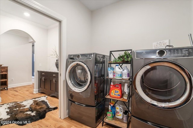 laundry area featuring crown molding and light hardwood / wood-style floors