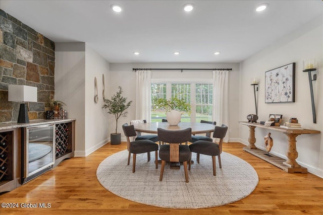 dining room with beverage cooler and light hardwood / wood-style flooring