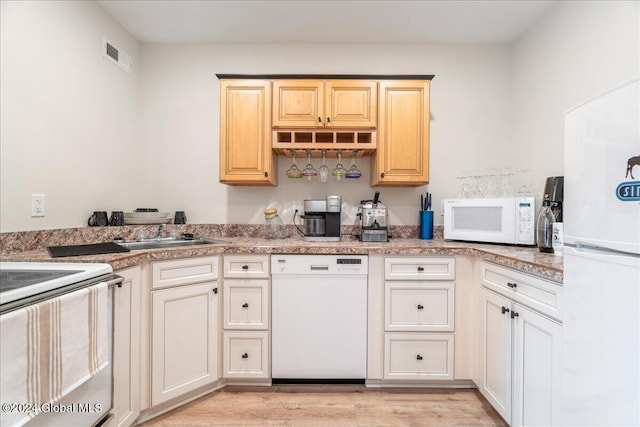 kitchen with white appliances, light hardwood / wood-style flooring, and sink