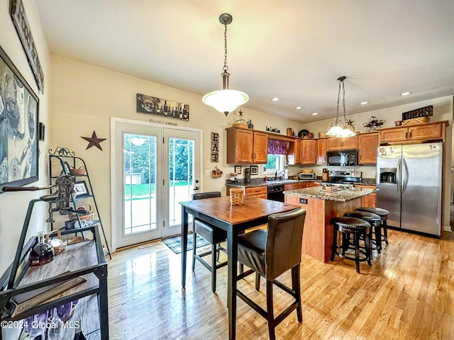 dining space with a healthy amount of sunlight, sink, and light hardwood / wood-style flooring