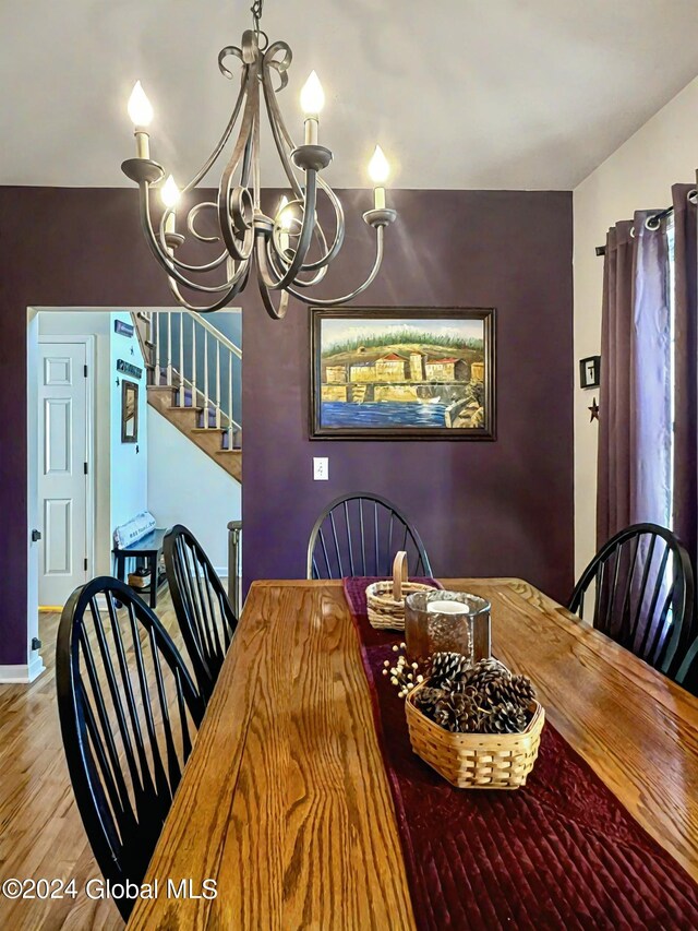 dining room with hardwood / wood-style flooring and an inviting chandelier