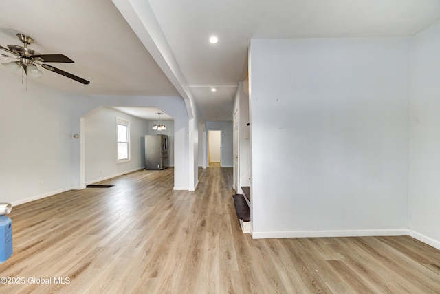 unfurnished room featuring light hardwood / wood-style floors and ceiling fan with notable chandelier