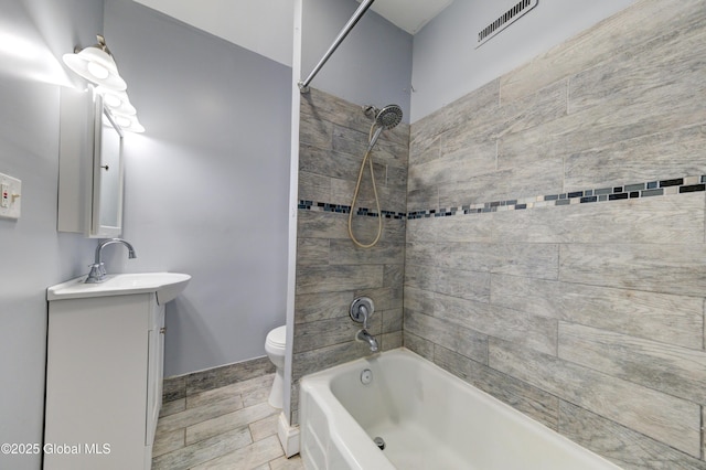 full bathroom featuring toilet, vanity, and tiled shower / bath combo