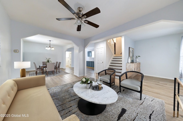 living room featuring wood-type flooring and ceiling fan with notable chandelier