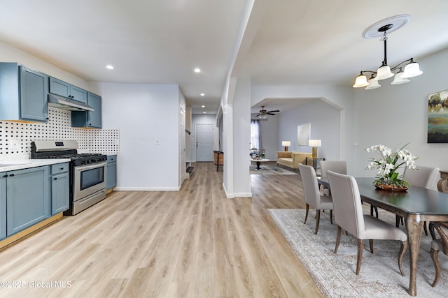 kitchen with blue cabinetry, ceiling fan, stainless steel range with gas cooktop, pendant lighting, and light wood-type flooring