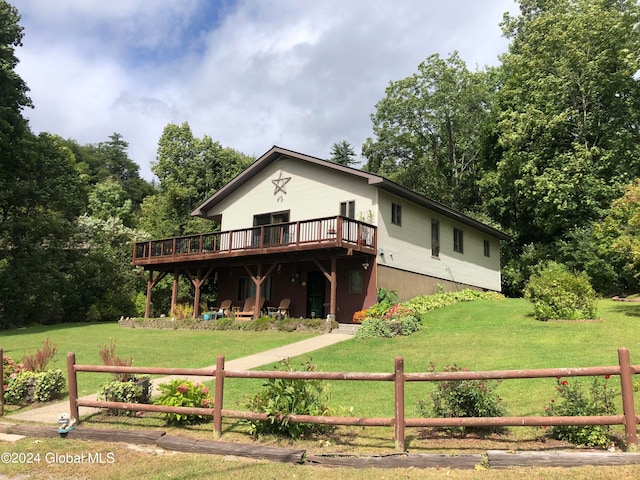 view of front facade featuring a front lawn and a wooden deck