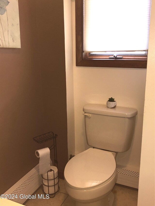 bathroom featuring toilet, a baseboard heating unit, and tile patterned flooring