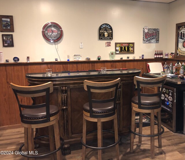 bar featuring wood walls and wood-type flooring