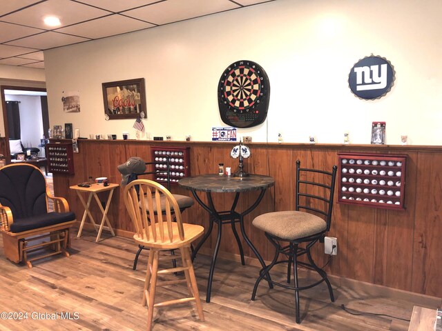 bar featuring hardwood / wood-style floors and wooden walls