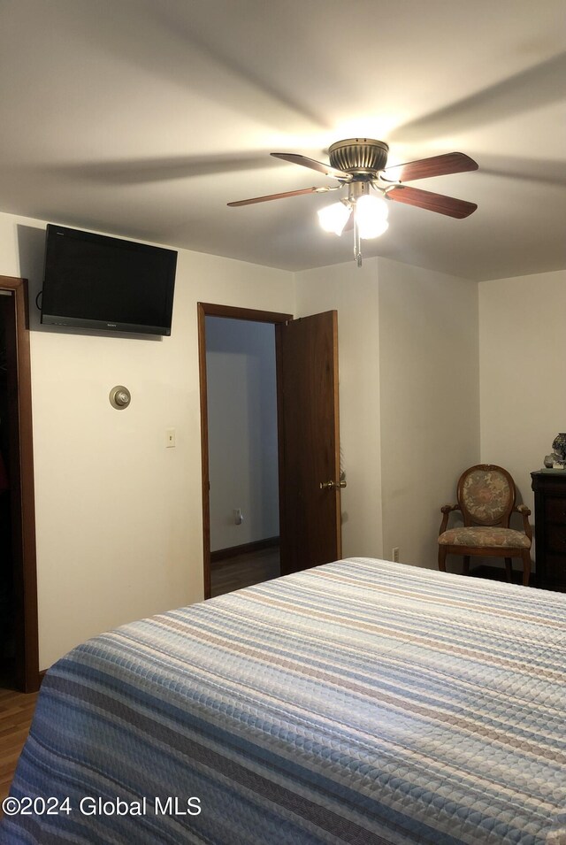 bedroom with dark hardwood / wood-style flooring and ceiling fan