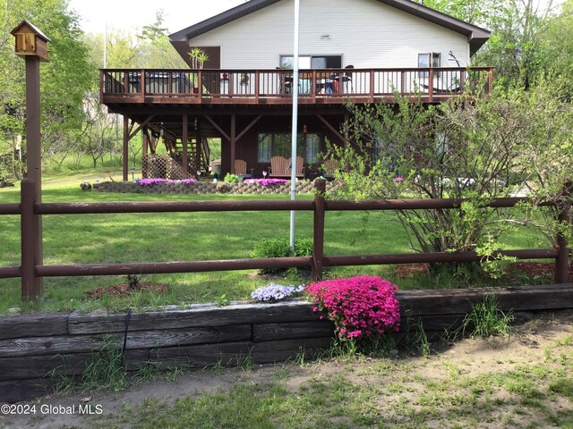 back of house featuring a wooden deck and a lawn