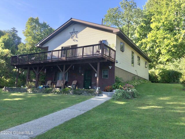 back of house with a deck and a lawn