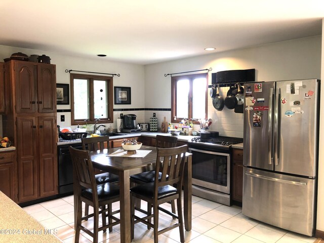 kitchen with tasteful backsplash, sink, stainless steel appliances, dark brown cabinetry, and light tile patterned floors