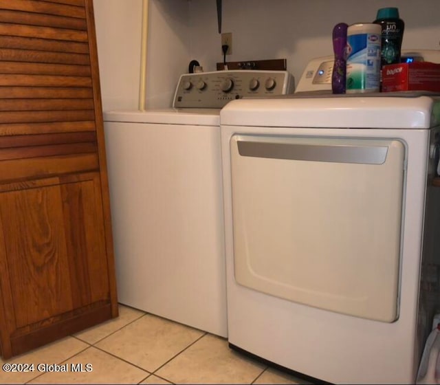 washroom with washer and dryer and light tile patterned floors