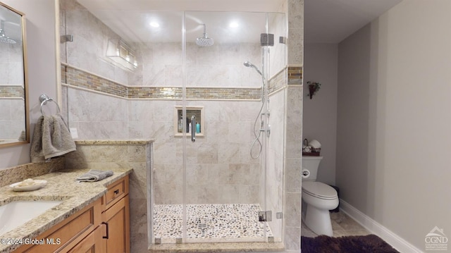 bathroom featuring tile patterned flooring, a shower with shower door, toilet, and vanity