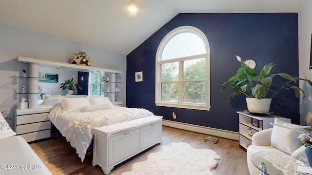 bedroom featuring a baseboard heating unit, vaulted ceiling, and hardwood / wood-style flooring