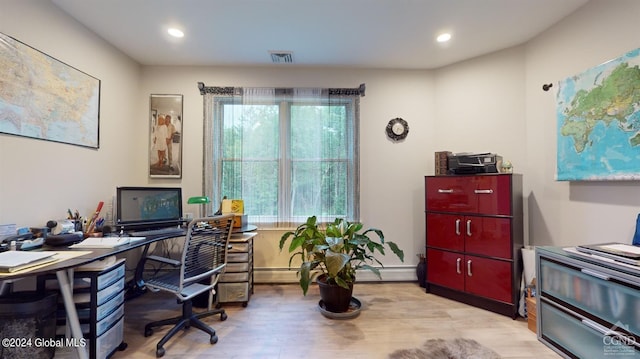 office area featuring a baseboard heating unit and light hardwood / wood-style flooring