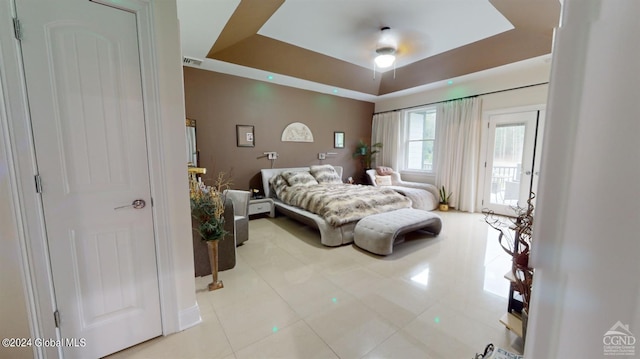 tiled bedroom featuring a tray ceiling