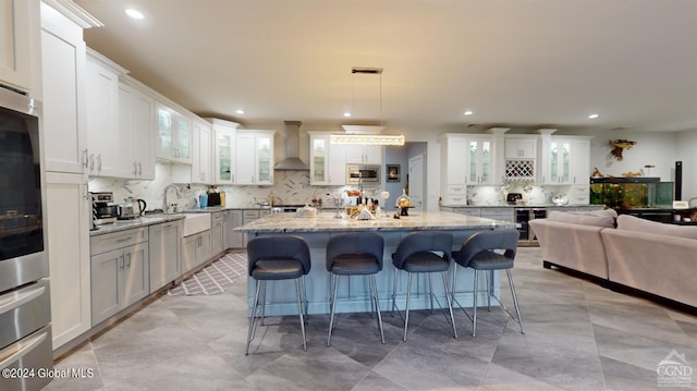 kitchen featuring a kitchen bar, a center island, stainless steel microwave, and white cabinets