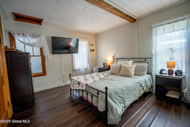 bedroom featuring multiple windows, dark hardwood / wood-style flooring, and beamed ceiling