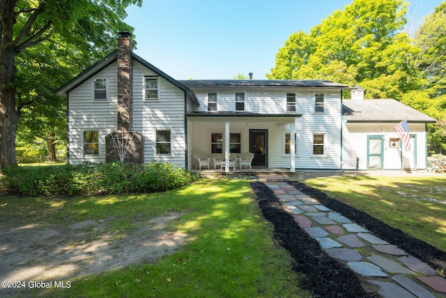 rear view of property with a yard and a patio