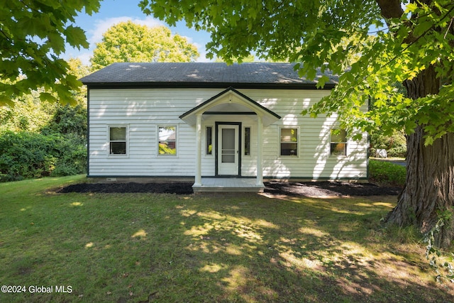 rear view of house featuring a lawn and a porch