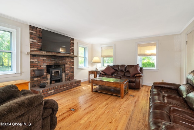 living room with a fireplace, plenty of natural light, and light hardwood / wood-style flooring