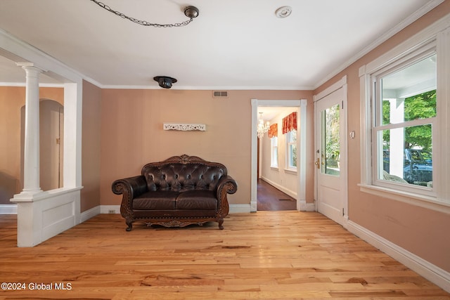 sitting room featuring crown molding, light hardwood / wood-style flooring, and ornate columns