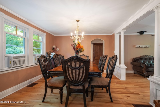 dining area with ornamental molding, ornate columns, a notable chandelier, and light hardwood / wood-style floors