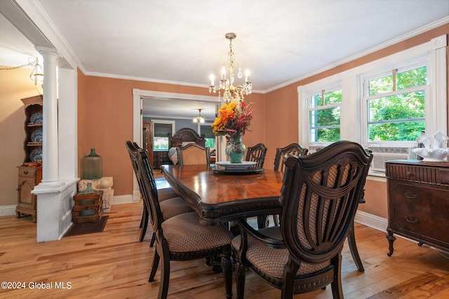 dining room with crown molding, a notable chandelier, decorative columns, and light hardwood / wood-style floors