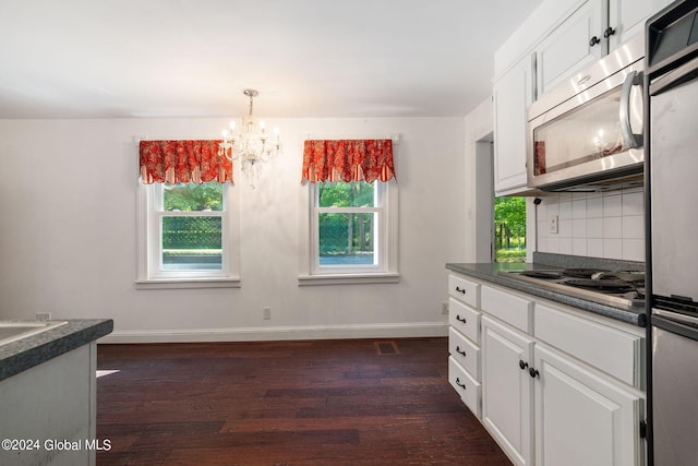 kitchen with white cabinetry, tasteful backsplash, stainless steel appliances, an inviting chandelier, and dark wood-type flooring