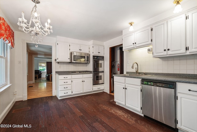 kitchen featuring tasteful backsplash, a chandelier, stainless steel appliances, dark wood-type flooring, and white cabinets